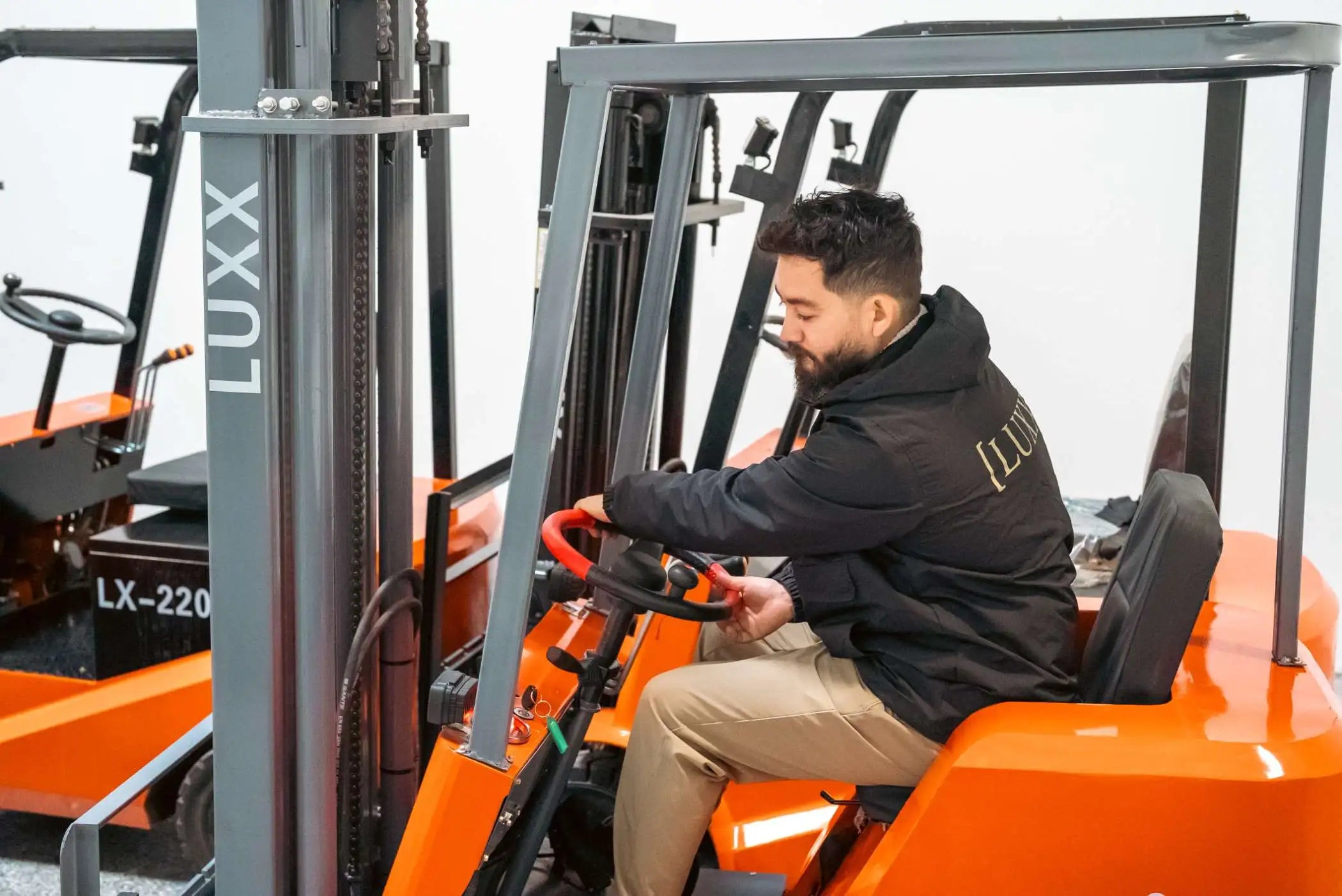 Three LUXX electric forklifts parked outdoors with masts fully raised, illustrating key forklift safety tips such as mast clearance awareness and safe parking procedures.