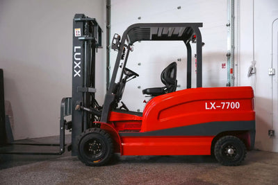 Side profile of the LUXX LX-7700 red forklift with black dual-mast, ergonomic operator seat, and overhead guard, parked near a white garage door.
